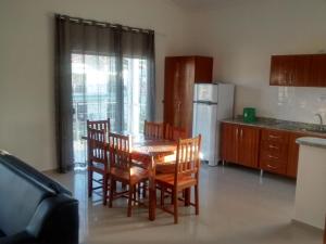 cocina con mesa, sillas y nevera en Residencial Golfinhos, en Porto Seguro