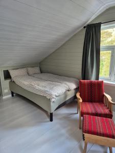 ein Bett und ein Stuhl in einem Zimmer in der Unterkunft Idyllic house with views - close to nature in Nydalen