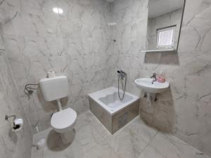 ein weißes Badezimmer mit Toilette und Waschbecken in der Unterkunft Vila Arapović, Maloševići 56 in Buna + 25 Fotos