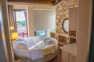 a room with a round bed and a stone wall at Kallisti Hotel in Potos