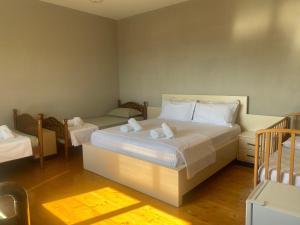 a bedroom with a large bed and two twin beds at Meti guest house in Krujë