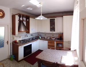 a kitchen with white cabinets and a table in it at Nonna Anita in Castelveccana