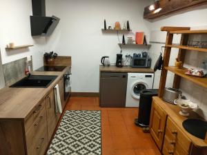 a kitchen with a sink and a washing machine at Gîte au coeur du Plantaurel in Cazaux