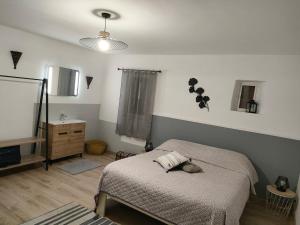 a bedroom with a bed and a dresser and a mirror at Gîte au coeur du Plantaurel in Cazaux