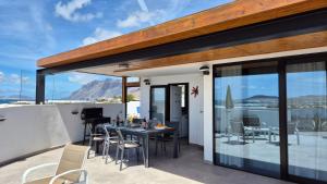 a patio with a table and chairs on a balcony at La Belle Vie in Famara