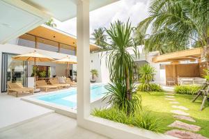 a house with a swimming pool and palm trees at Villa Natali - Lamai in Amphoe Koh Samui