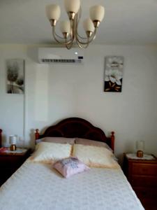 a bedroom with a bed and a chandelier at Casa Jardim in Ponta do Pargo