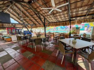 a restaurant with tables and chairs and a ceiling at Hotel Los Veleros Santa Marta in Santa Marta