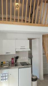 フロワラックにあるNid'ZEN Floirac près de Bordeauxの白いキャビネットとカウンタートップを備えたキッチン