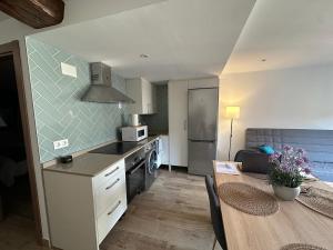 a kitchen with a table and a dining room at Apartamentos Rurales La Estrella in Casar de Palomero +16 photos