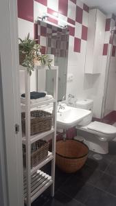 un baño con lavabo e inodoro en Apartamento Galería Cine Colón, en Ribadeo 13 fotos más