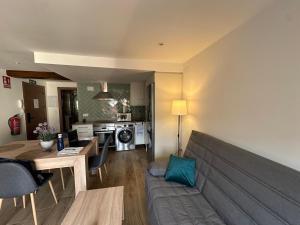 a living room with a couch and a kitchen at Apartamentos Rurales La Estrella in Casar de Palomero
