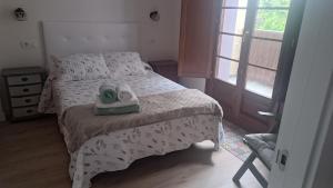 a bedroom with a bed with a pair of shoes on it at Apartamento Galería Cine Colón in Ribadeo