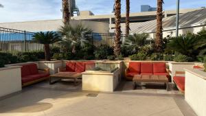 Un patio con muebles rojos y palmeras. en MGM Signature Studios by FantasticStay, en Las Vegas 13 fotos más