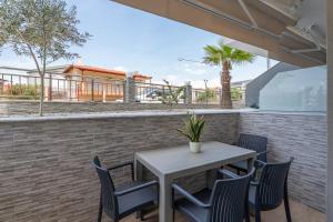 ニキティにあるOASIS luxury apartments and rooms nikitiのレンガの壁のパティオ(テーブル、椅子付)