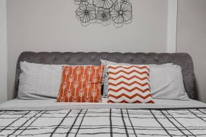 a bed with pillows on it with a head board at Grand Carytown 5BR FAN HOME fully fenced in Richmond +39 photos