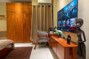 a living room with a large television and a chair at Maison Kéfi in Bingerville