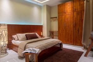 a bedroom with a large bed and wooden cabinets at Maison Kéfi in Bingerville