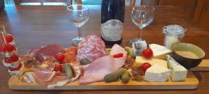a plate of different types of cheese and wine glasses at 2 Yourtes au naturel in Druyes-les-Belles-Fontaines