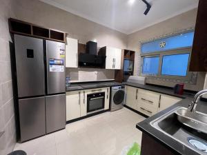 a kitchen with a stainless steel refrigerator and a sink at Modern 3 bedroom Penthouse in Cairo