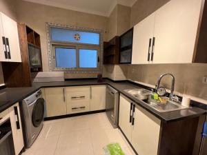 a kitchen with a sink and a washing machine at Modern 3 bedroom Penthouse in Cairo +10 photos