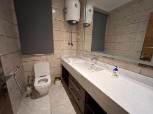 a bathroom with a toilet and a sink and a mirror at Modern 3 bedroom Penthouse in Cairo