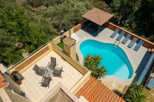 an overhead view of a swimming pool with chairs and an umbrella at Ocean in Hersonissos