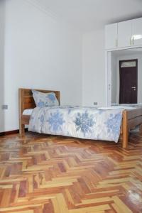 a bedroom with a bed and a wooden floor at Large Villa with Driver Included in Addis Ababa