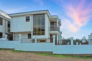 a white house with a fence around it at Large Villa with Driver Included in Addis Ababa
