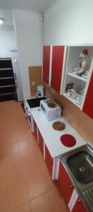 a kitchen with red and white cabinets and a sink at Blue Butterfly Apartment - Cozy and Stylish Stay in Sibiu