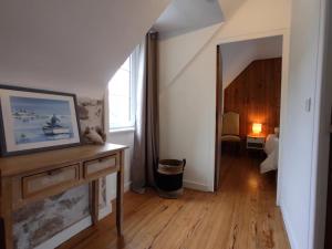 a living room with a wooden floor and a hallway at NOUVEAU YS EO, La maison sur le port de Tréboul in Douarnenez