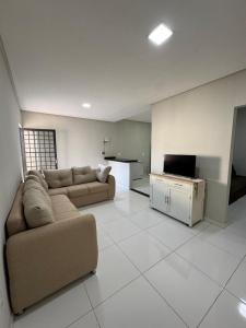 a large living room with a couch and a kitchen at Casa aconchegante in Petrolina