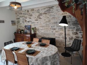 a dining room with a table and a stone wall at NOUVEAU YS EO, La maison sur le port de Tréboul in Douarnenez +19 photos