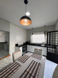 a kitchen with a white table and chairs and a kitchen with at Casa aconchegante in Petrolina