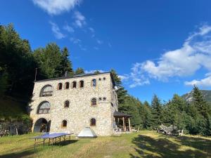 a large stone building with a table in front of it at Kulla Guest House in Peje