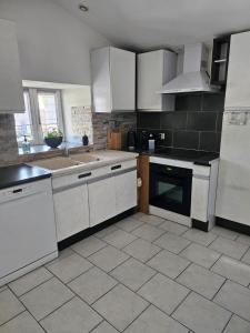 a kitchen with white appliances and a tile floor at Appartement 2 chambres - Idéal pro & familles in Mussidan +9 photos