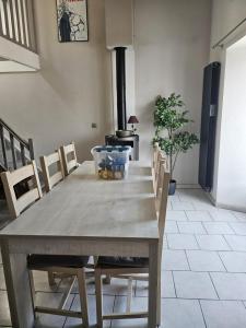 a dining room with a table with chairs and a stove at Appartement 2 chambres - Idéal pro & familles in Mussidan