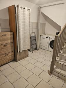 a laundry room with a washer and a staircase at Appartement 2 chambres - Idéal pro & familles in Mussidan