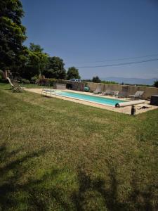 a swimming pool in a yard next to a grass field at EPICEAH Loft à la campagne à 10 mn de Valence in Valence