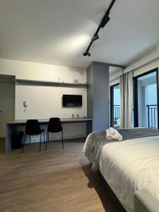 a bedroom with a bed and a desk with two chairs at Modern studio in Santa Cecilia in Sao Paulo
