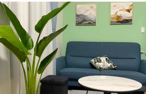 a living room with a blue couch and a table at Beautiful Villa in Shanhua +2 photos