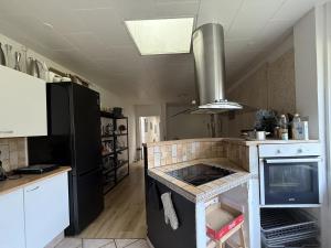 a kitchen with a stove top oven in a kitchen at Cozy Room in the heart of Rødby! 5km from Femern & Puttgarden! in Rødby +18 photos