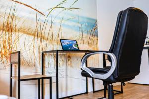 a black chair with a laptop on a desk at Le Nid du Marin in Lorient