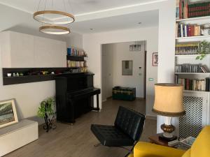 a living room with a piano and a chair at Penthouse in the historic center in Brindisi