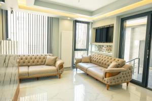 a living room with two couches and a tv at Airport Bayrak Residences Trabzon in Trabzon