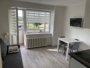 a living room with a table and a window at Gelezinis in Vilnius