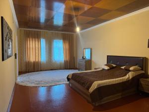 a bedroom with a large bed and a ceiling at Дом для отдыха in Sǝrdakhar +1 photo