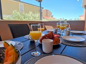 a table with food and glasses of orange juice at Apartments Davor in Drage