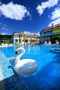 a swan swimming in a swimming pool at PoolView Elite Apartment in RoseGardenComplex with BigPool and Parking in Balchik