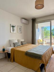 ein Schlafzimmer mit großem Bett und Balkon in der Unterkunft Studio Vue Mer - Boucan Canot Cap Homard in Saint-Paul